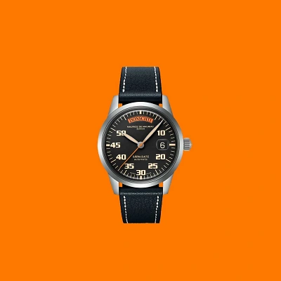 Maurice de Mauriac B&Auml;RN-DATE Uhr vor kr&auml;ftigem Orange-Hintergrund. Klare Linien, sportlich-elegantes Design und Schweizer Pr&auml;zision vereint in einem ikonischen Zeitmesser.