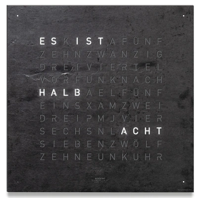 Die QLOCKTWO EARTH 45 in METAMORPHITE ist in der Front Ansicht. Ein stilvolles Kunstwerk wo jedes Exemplar ist ein Unikat, gefertigt auf echtem Stein.  Und das ikonische Buchstabenraster, das die Uhrzeit in Worten darstellt.